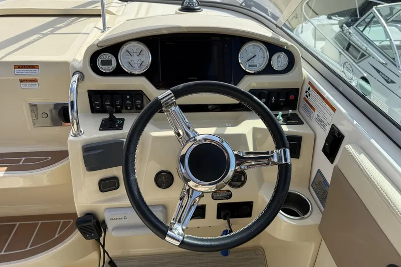 Slide: The Image of 2019 Regal 28 Express boat dashboard with steering wheel and gauges. - 11