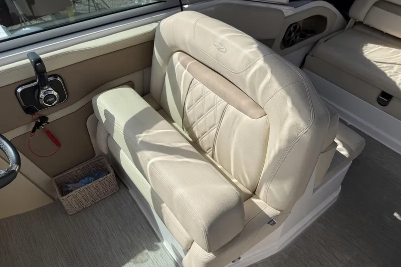 Slide: The Image of 2019 Regal 28 Express boat interior with beige leather seating and control panel. - 12