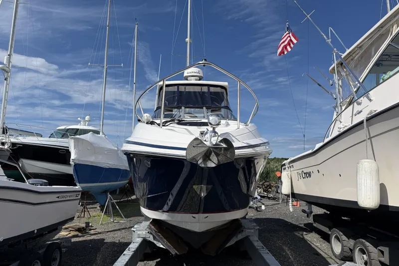 Slide: The Image of 2019 Regal 28 Express boat on trailer, surrounded by other boats, under clear blue sky. - 3