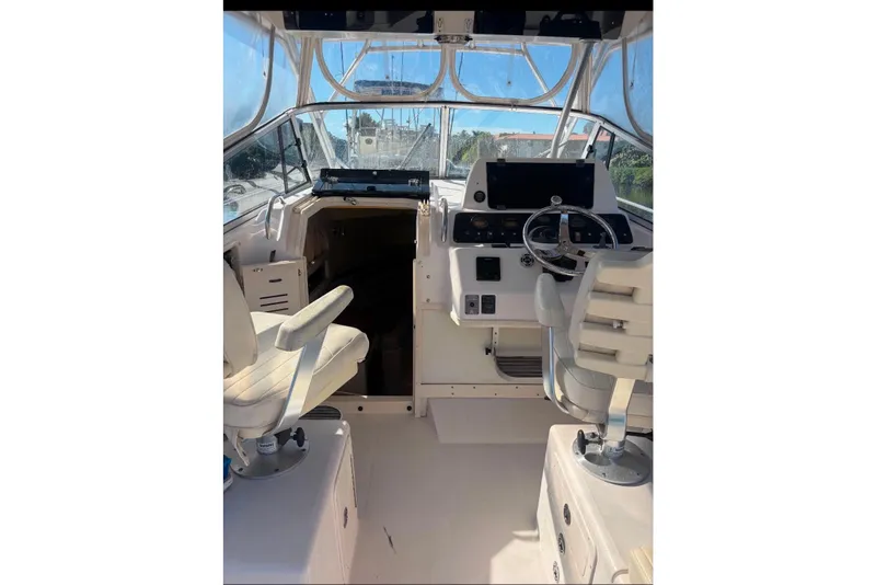 Slide: The Image of 2004 Grady-White Marlin 300 boat interior with helm and seating area. - 2