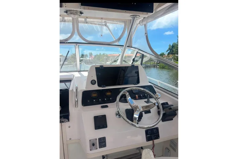 Slide: The Image of 2004 Grady-White Marlin 300 helm with steering wheel and navigation controls. - 3
