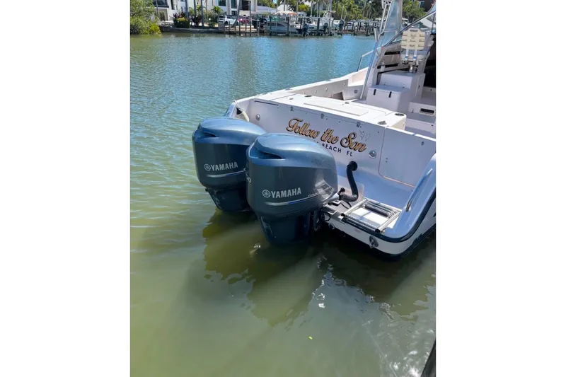Slide: The Image of 2004 Grady-White Marlin 300 boat with twin Yamaha outboard motors on a calm waterway. - 6