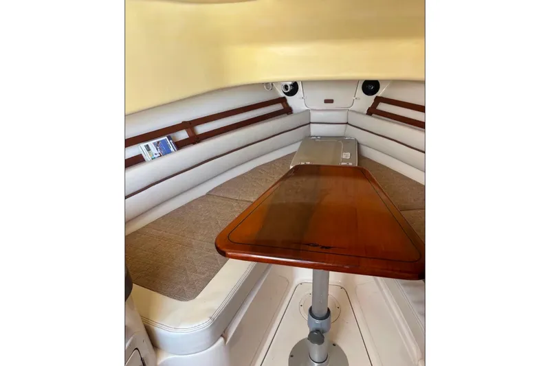 Slide: The Image of 2004 Grady-White Marlin 300 cabin interior with wooden table and cushioned seating. - 5