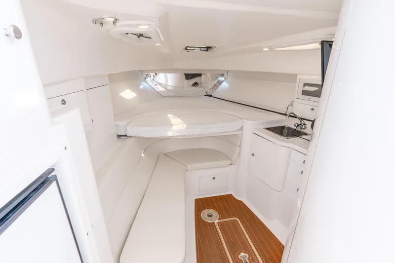 Slide: The Image of 2003 Intrepid 348 Walkaround cabin interior with bed, sink, and wooden flooring. - 29