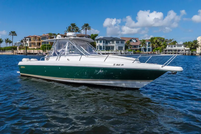 The Image of 2003 Intrepid 348 Walkaround boat on water, with luxury homes in the background. - 1