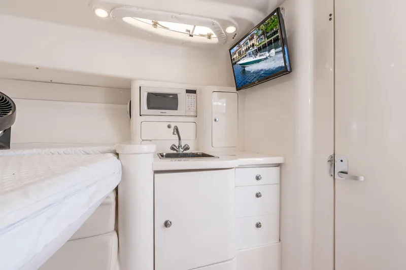 Slide: The Image of 2003 Intrepid 348 Walkaround cabin interior with kitchenette, microwave, and TV. - 30
