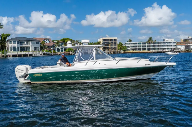 Slide: The Image of 2003 Intrepid 348 Walkaround boat cruising on a sunny day near waterfront homes. - 9