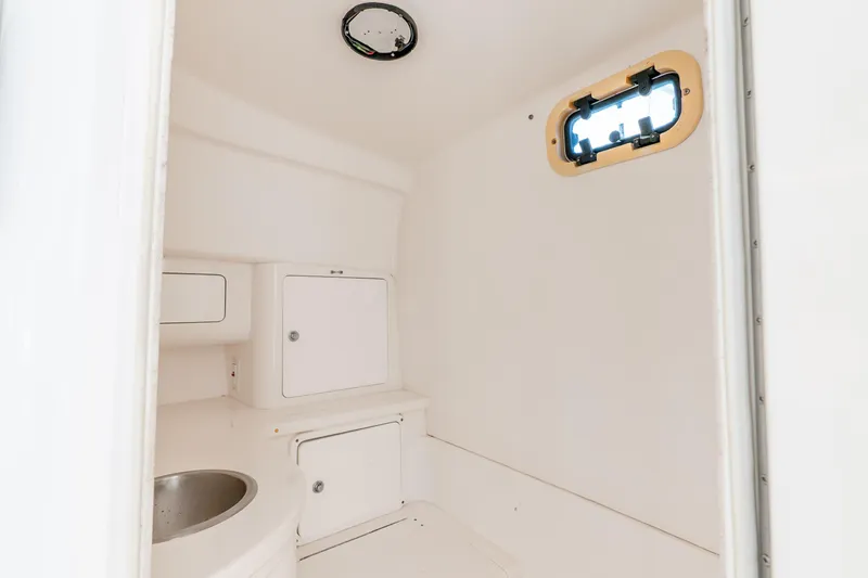 Slide: The Image of Interior cabin of 2003 Intrepid 348 Walkaround boat, featuring a compact sink and storage compartments. - 31