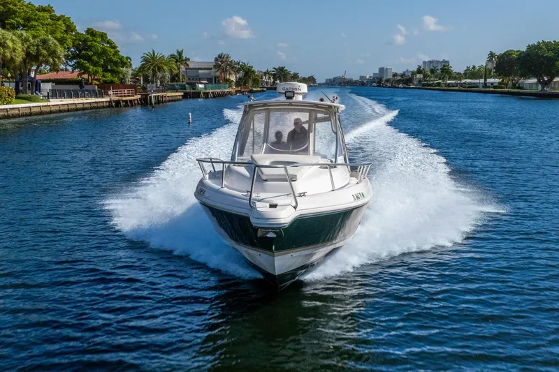 Slide: The Image of 2003 Intrepid 348 Walkaround boat cruising on a scenic waterway. - 4