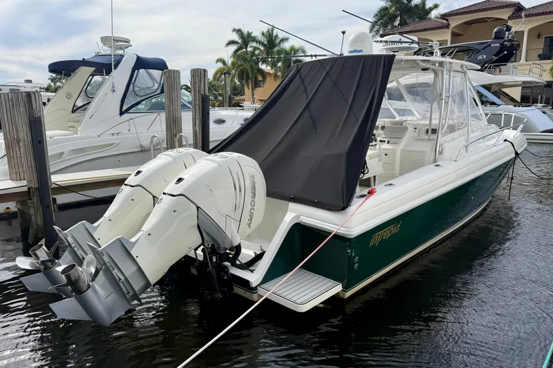 Slide: The Image of 2003 Intrepid 348 Walkaround boat docked with twin Mercury outboard engines. - 1