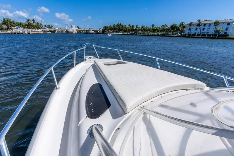 Slide: The Image of 2003 Intrepid 348 Walkaround boat cruising on a sunny day, with scenic waterfront views. - 21