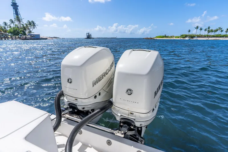 Slide: The Image of Twin Mercury outboard engines on a 2003 Intrepid 348 Walkaround boat, ocean backdrop. - 19
