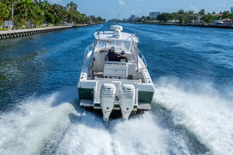 Slide: The Image of 2003 Intrepid 348 Walkaround cruising on a scenic waterway, showcasing powerful dual engines. - 10