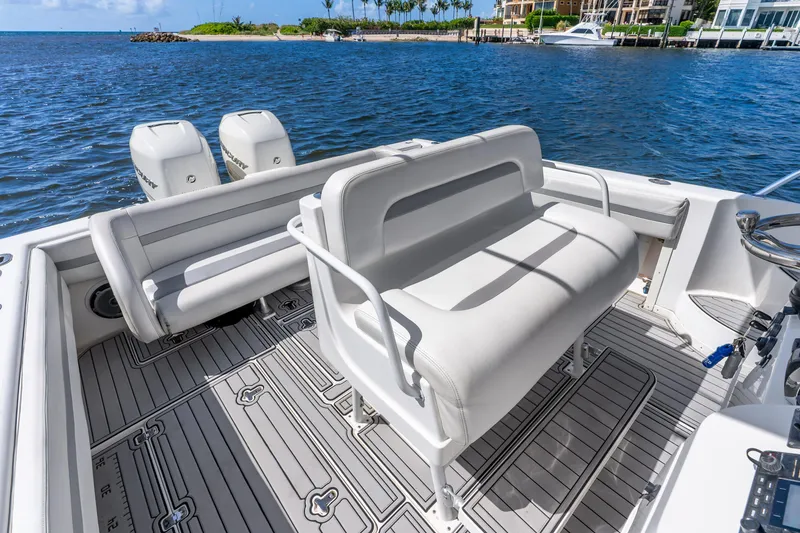 Slide: The Image of 2003 Intrepid 348 Walkaround boat interior with seating and twin outboard engines on a sunny day. - 27