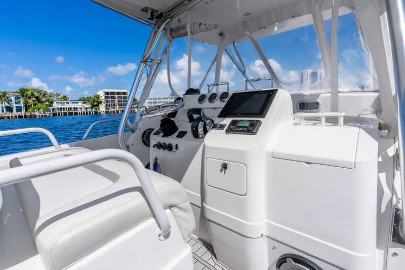 Slide: The Image of 2003 Intrepid 348 Walkaround boat interior with modern dashboard and scenic waterfront view. - 26