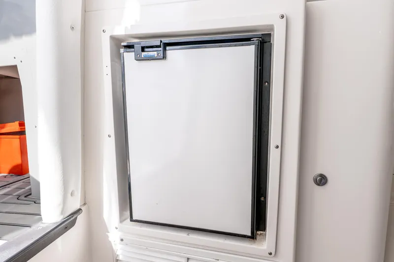 Slide: The Image of Built-in refrigerator on a 2003 Intrepid 348 Walkaround boat, featuring a sleek white design. - 32