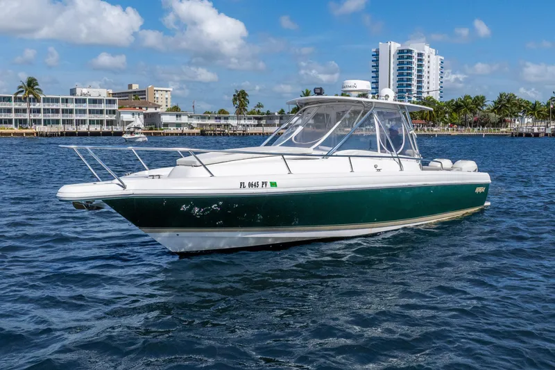 Slide: The Image of 2003 Intrepid 348 Walkaround boat on water, with cityscape and palm trees in background. - 3