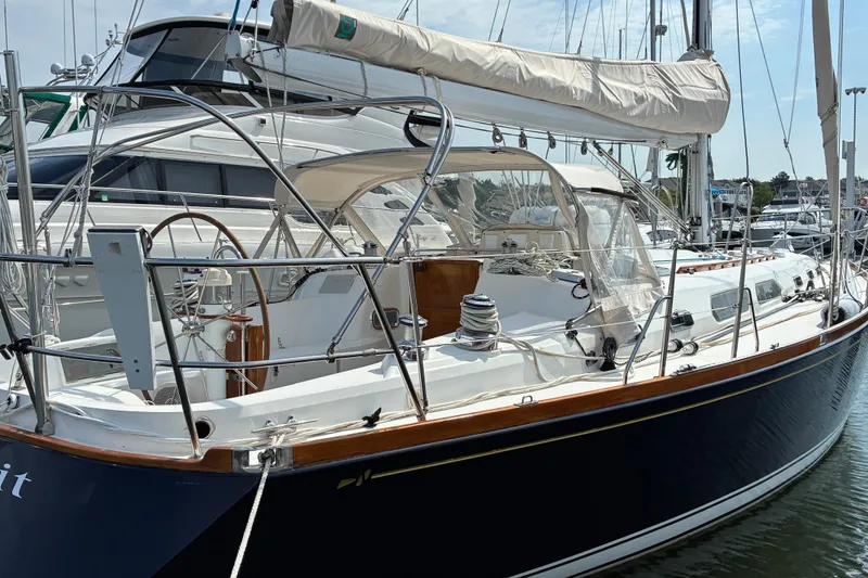 Slide: The Image of Sleek 1999 Sabre 452 sailboat docked, showcasing elegant design and polished wood accents. - 1