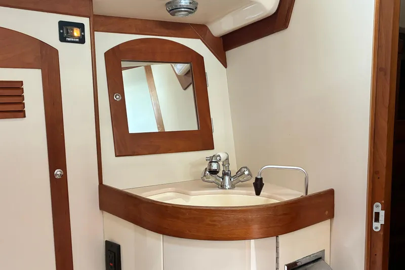 Slide: The Image of Wood-trimmed bathroom sink area in a 1999 Sabre 452 yacht. - 45