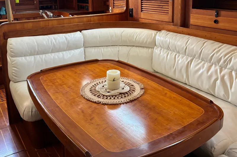 Slide: The Image of Cozy dining area in a 1999 Sabre 452 yacht with wooden table and cushioned seating. - 25