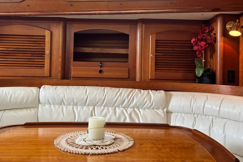 Slide: The Image of Luxurious Sabre 452 yacht interior with wooden cabinets, white seating, and decorative candle. - 26