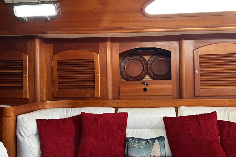 Slide: The Image of Cozy Sabre 452 yacht interior with wooden cabinets, red cushions, and nautical-themed decor. - 35