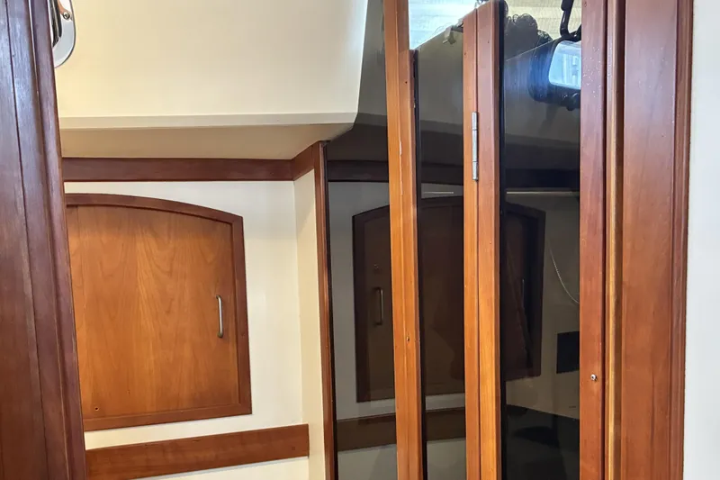Slide: The Image of Interior of a 1999 Sabre 452 yacht featuring wooden cabinetry and mirrored doors. - 38