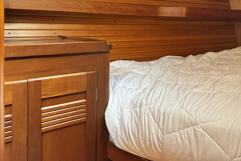 Slide: The Image of Wooden interior of a 1999 Sabre 452 yacht with a cozy bed and cabinet. - 41