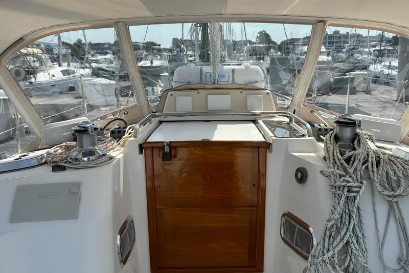 Slide: The Image of Cockpit of a 1999 Sabre 452 sailboat, featuring ropes and winches in a marina setting. - 10