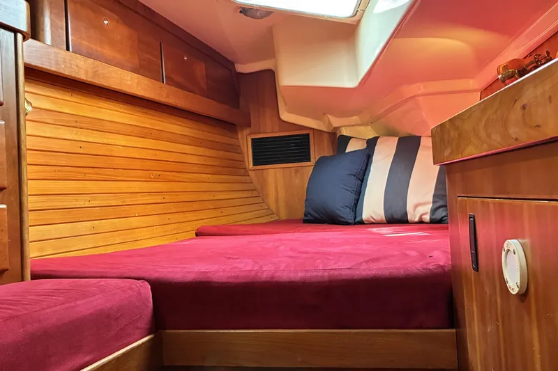 Slide: The Image of Cozy cabin interior of 1999 Sabre 452 yacht with red bedding and wooden paneling. - 47