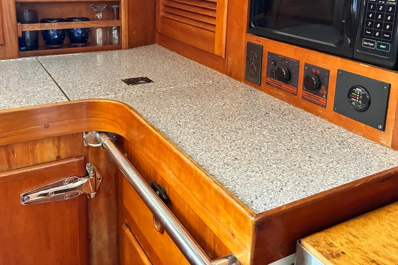 Slide: The Image of 1999 Sabre 452 yacht interior with wooden cabinetry and granite countertop in the galley. - 20