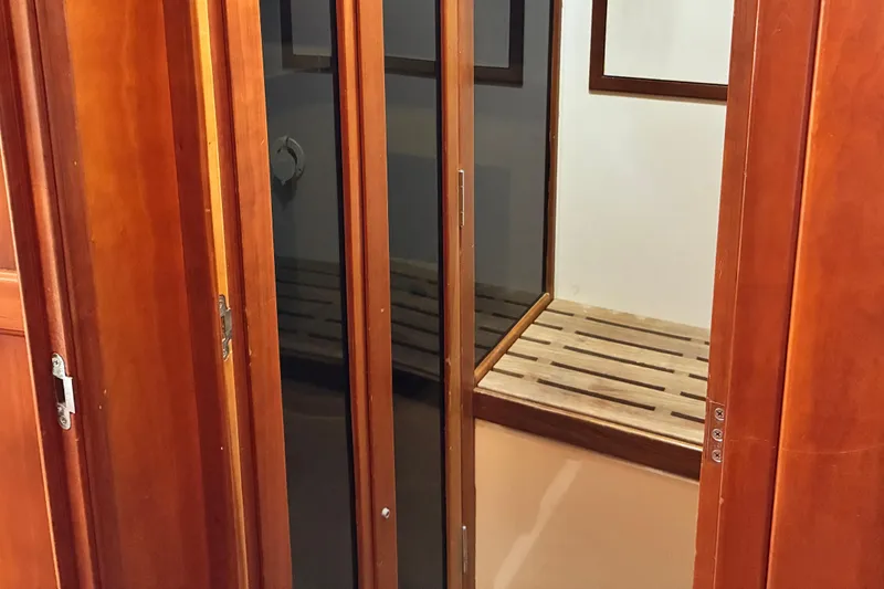 Slide: The Image of Wooden interior of a 1999 Sabre 452 yacht, featuring a sliding door and bench. - 39