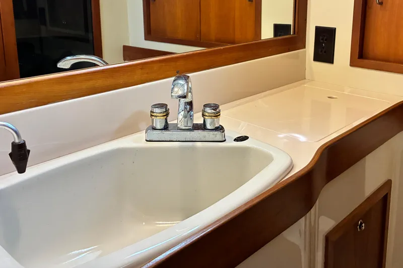 Slide: The Image of 1999 Sabre 452 yacht bathroom sink with wooden accents and modern fixtures. - 37