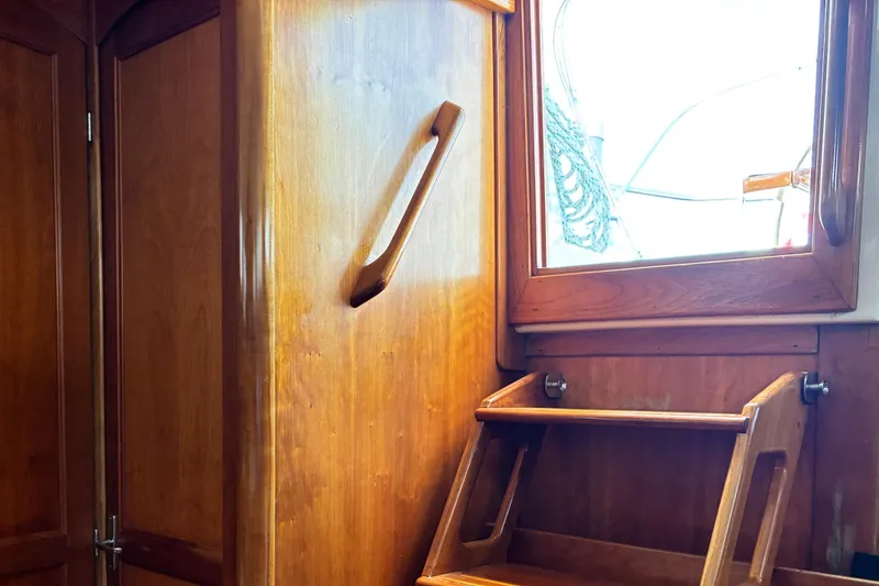 Slide: The Image of Interior of a 1999 Sabre 452 yacht, featuring wooden cabinetry and a window. - 16