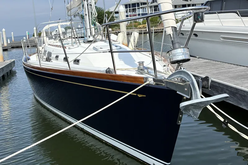 Slide: The Image of Sleek 1999 Sabre 452 sailboat docked, showcasing elegant design and polished wood accents. - 2