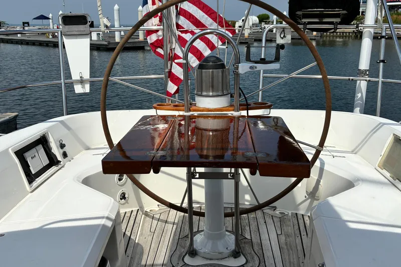 Slide: The Image of Cockpit of 1999 Sabre 452 sailboat with wooden table and American flag. - 6