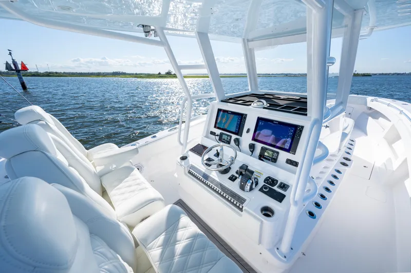 Slide: The Image of 2022 Invincible 39 Open Fisherman boat interior with advanced navigation system on a sunny day. - 16