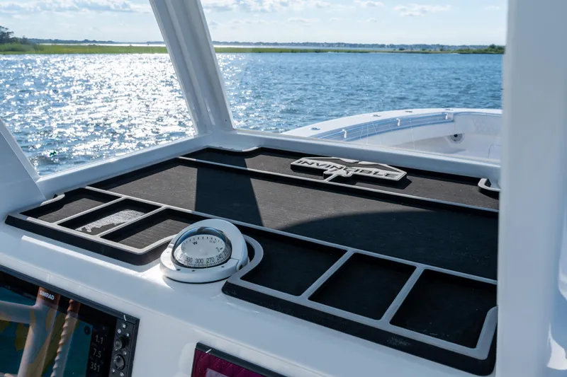 Slide: The Image of 2022 Invincible 39 Open Fisherman boat dashboard with compass, on a sunny day at sea. - 19