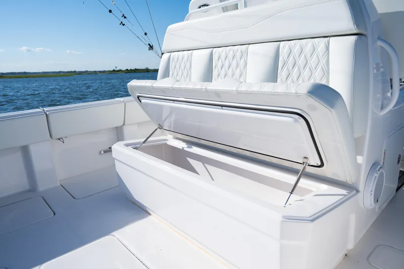 Slide: The Image of 2022 Invincible 39 Open Fisherman boat with open storage compartment, white seating, and ocean backdrop. - 30