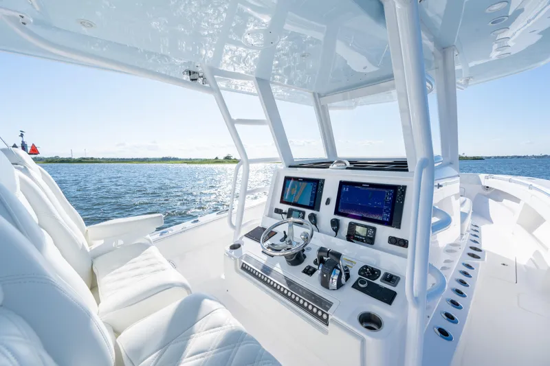 Slide: The Image of 2022 Invincible 39 Open Fisherman boat cockpit with advanced navigation systems on a sunny day. - 17