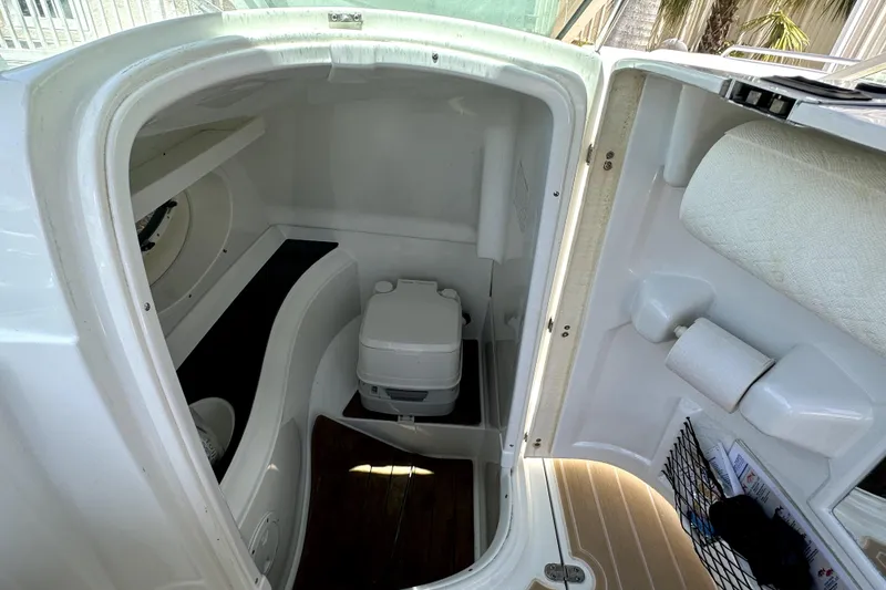 Slide: The Image of 2014 SouthWind 2400 SD boat interior with compact toilet and storage space. - 10