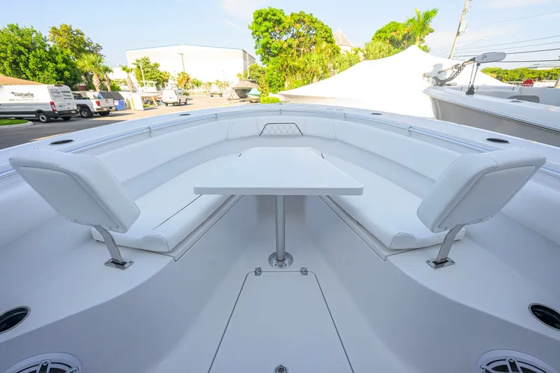 Slide: The Image of 2027 Sportsman Open 262 Center Console boat with white seating and table in the bow area. - 12