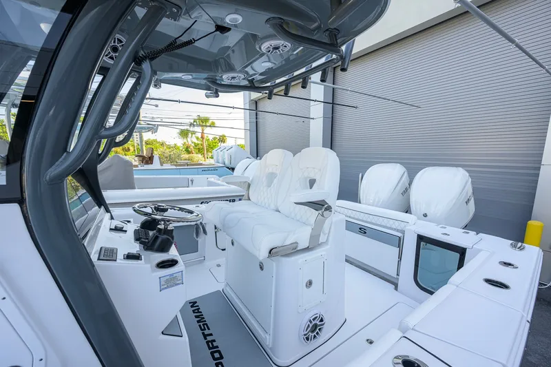 Slide: The Image of 2027 Sportsman Open 262 Center Console boat interior with white seating and dual engines. - 8