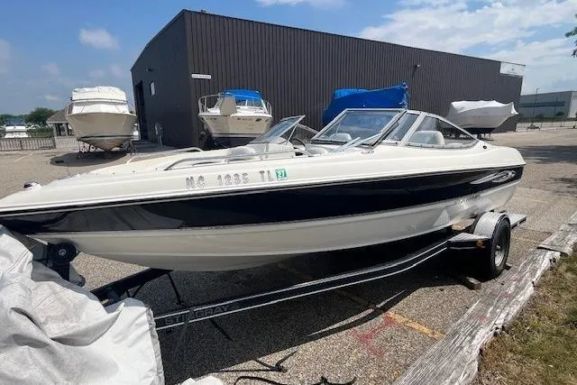 Slide: The Image of 2008 Stingray 195 LX boat on trailer, parked outdoors near other boats. - 1