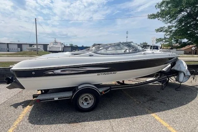 The Image of 2008 Stingray 195 LX boat on trailer, parked outdoors under a cloudy sky. - 0