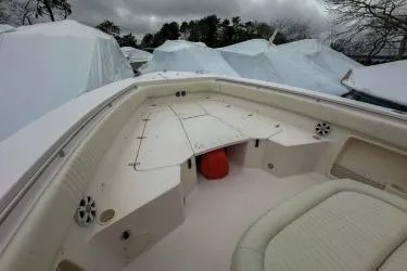 Slide: The Image of 2011 Grady-White Canyon 366 boat interior with seating and storage, covered in winter tarps. - 5