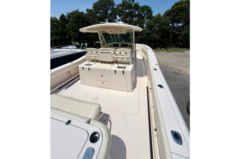 Slide: The Image of 2011 Grady-White Canyon 366 boat interior with seating and storage, docked outdoors. - 21