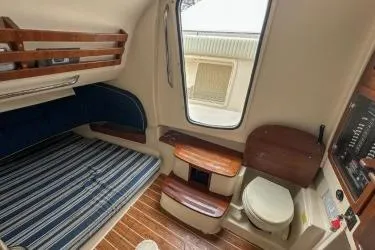 Slide: The Image of 2011 Grady-White Canyon 366 cabin interior with bed, window, and compact bathroom. - 15