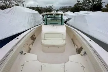 Slide: The Image of 2011 Grady-White Canyon 366 boat with spacious deck and seating, surrounded by covered boats. - 4