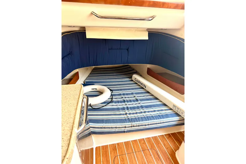 Slide: The Image of Interior cabin of 2011 Grady-White Canyon 366 with striped bedding and wooden flooring. - 31
